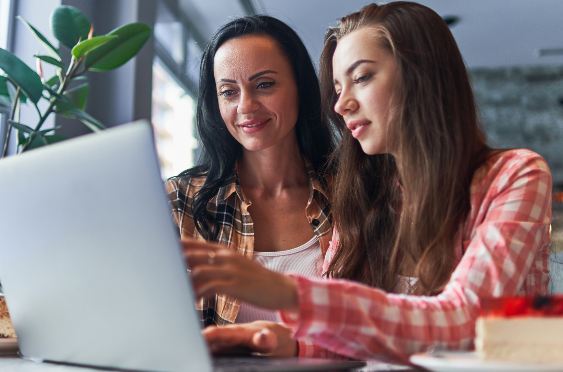 Eine Mutter sitzt mit ihrer Tochter vor einem Laptop